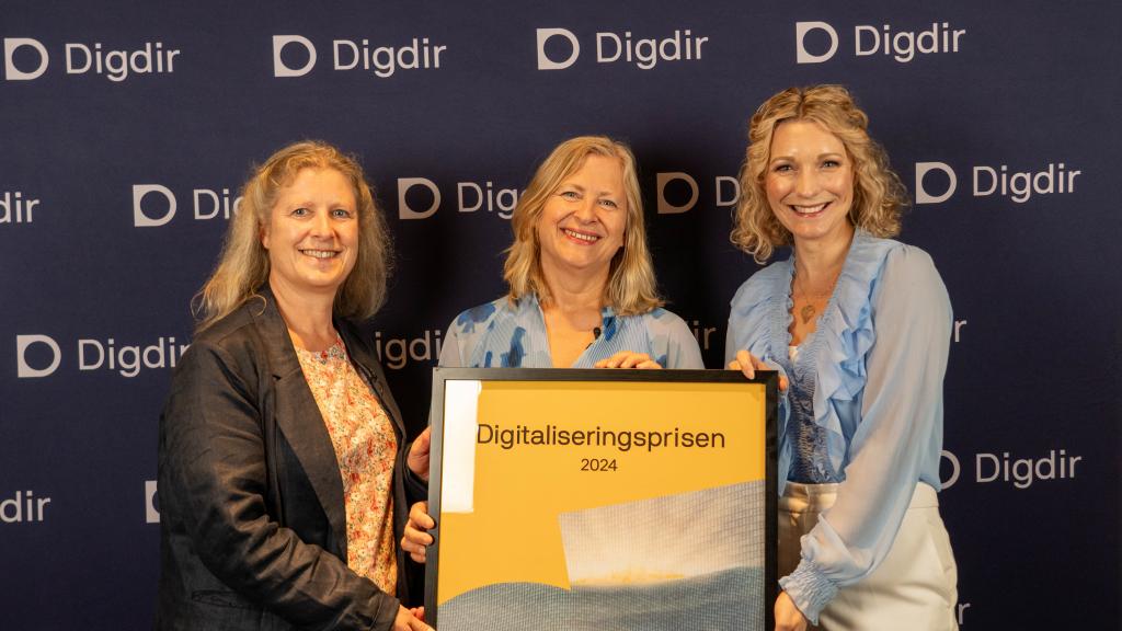 Tre holder opp Digitaliseringsprisen, som er et bilde.