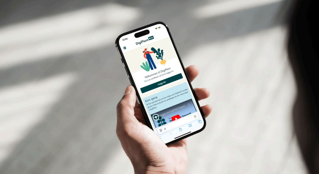 ånd som holder en smarttelefon som viser appen DigiPlant.